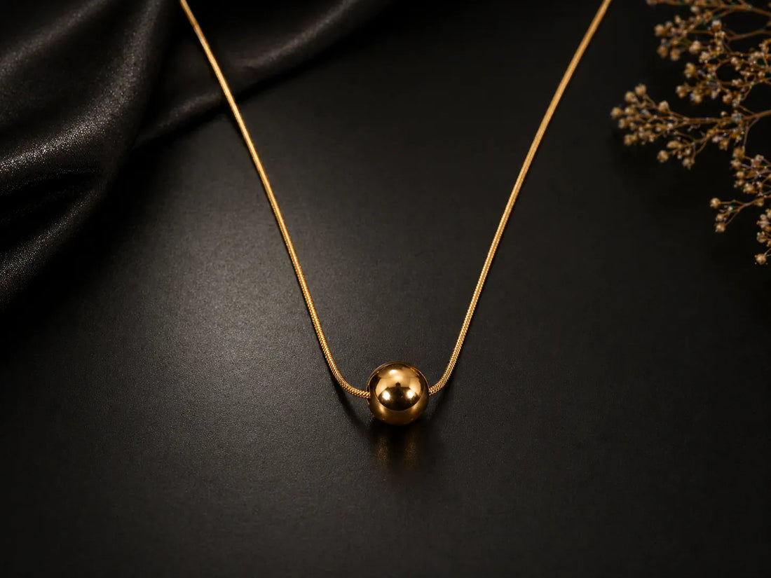 Collier doré avec pendentif boule