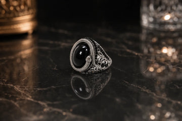 Bague argentée avec pierre noire entourée d’un serpent